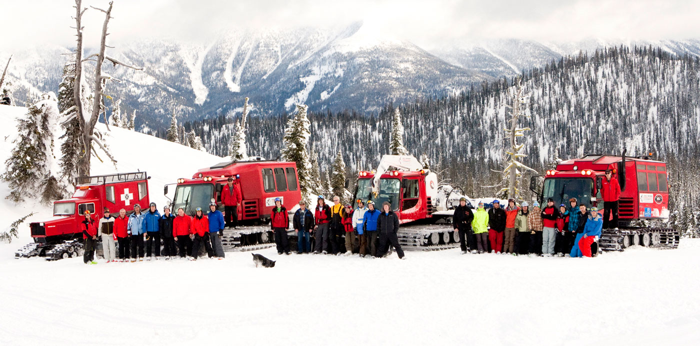 Three GNPG guest groups preparing to go on a full-day cat skiing adventure with cat skis behind them