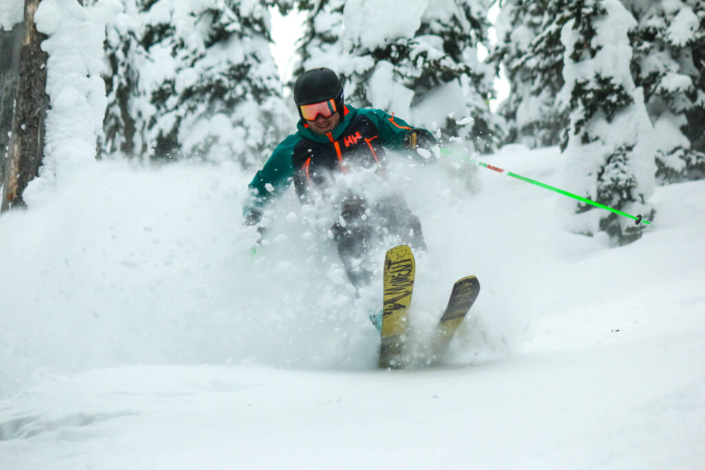 Advanced skier descending a powder slope in Montana’s Northern Rockies