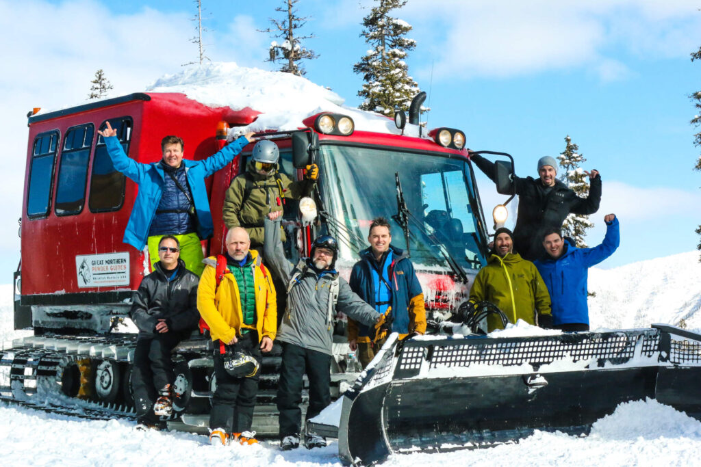 Guests gathered around cat ski machine preparing for Montana backcountry skiing.