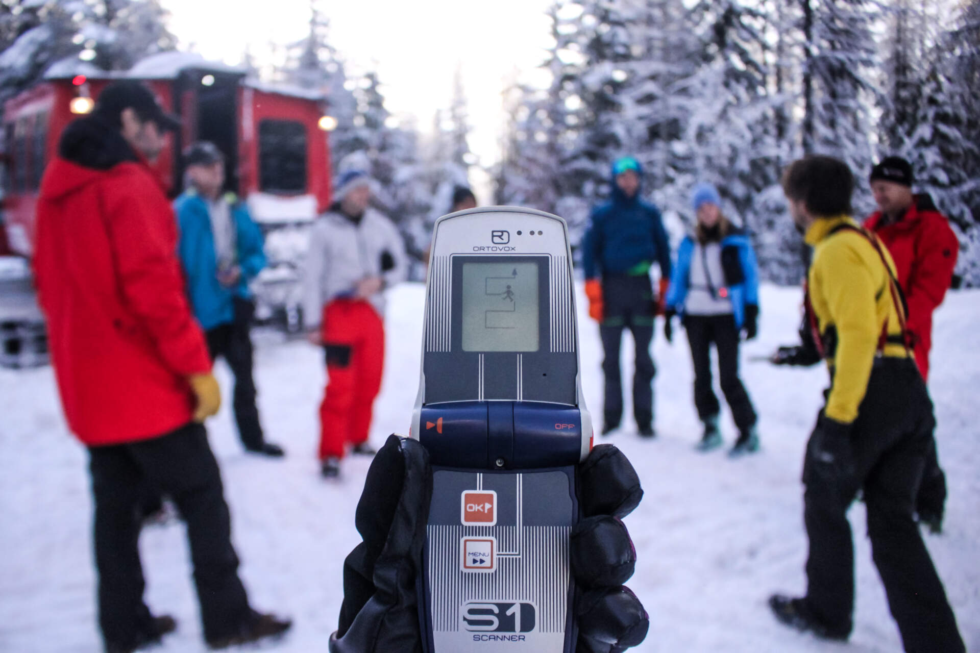 kostick-3 GNPG guide holding avalanche transceiver for hands-on training session.