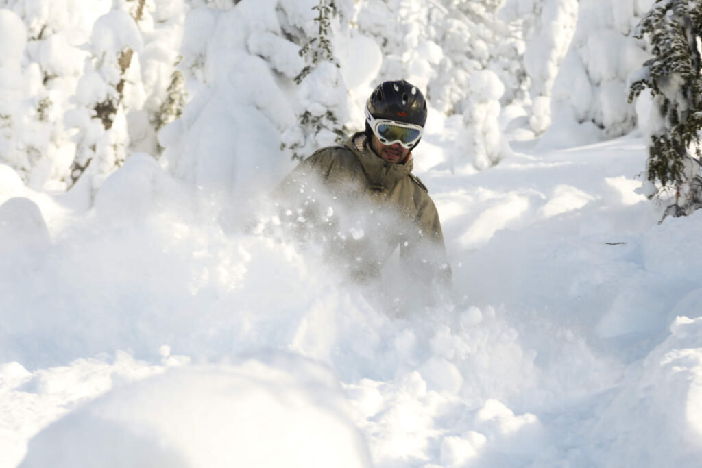skier descending a powder slope in Montana’s Northern Rockies.