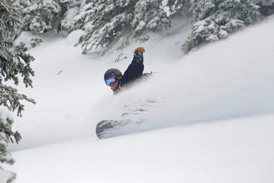 Snowboarder slashing a powder turn on untouched Northern Rockies terrain