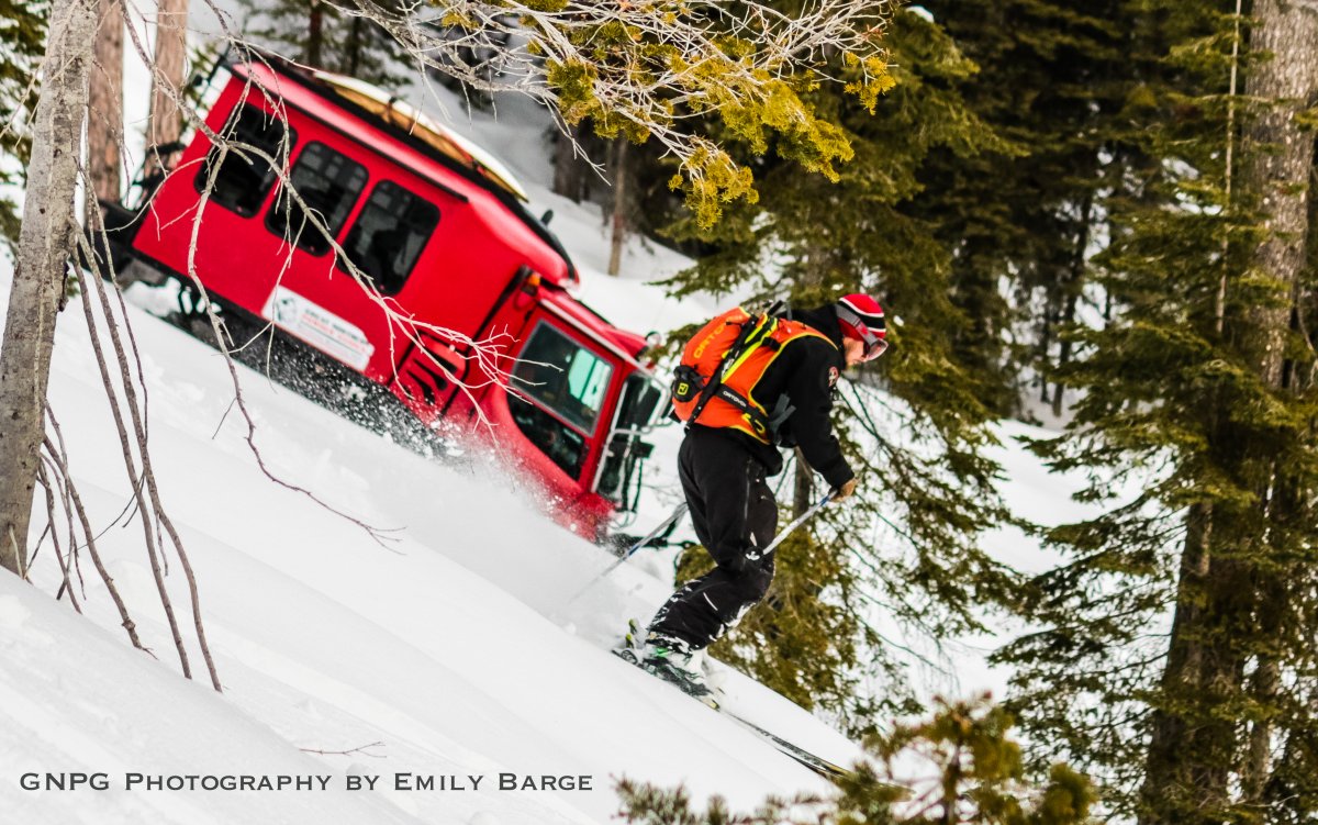 Skier descending powder slope in Montana backcountry with avalanche gear and safety backpack