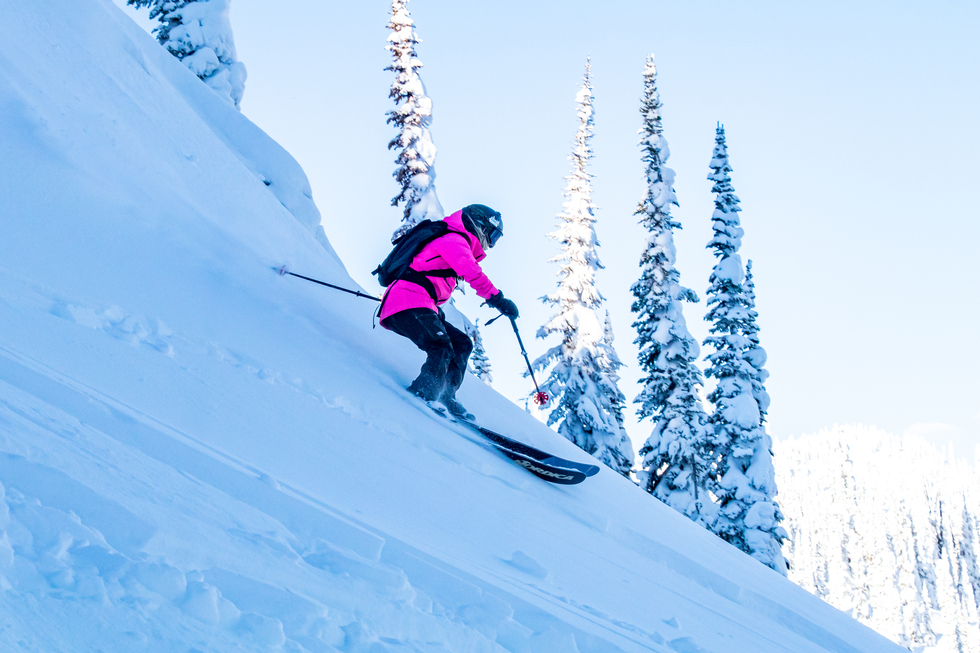 Backcountry skier descending through glades during a GNPG trip
